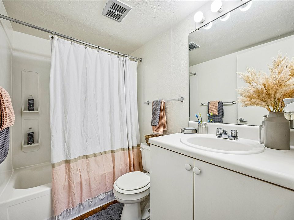 Refresh in a modern bathroom with granite countertops and a shower-tub combo at University Hills Apartments near the University of Toledo.