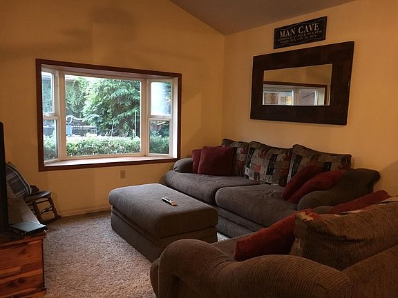 Living room with bay window that overlooks the garden. Furniture shown included.