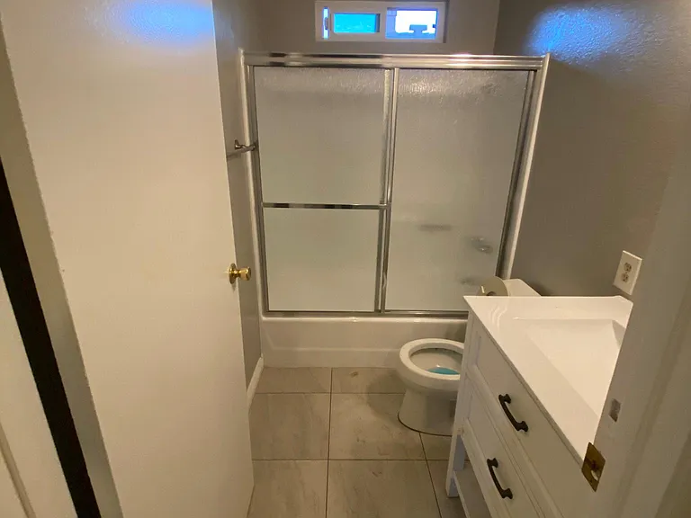 Bathroom 2 with newly refurbished shower , new shower doors and new tile flooring.