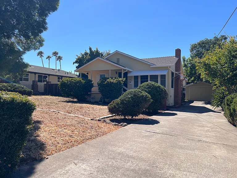 Long driveway leading to the garage. Spacious front yard and shade tree, large porch that feels private with the shrubs in front.
