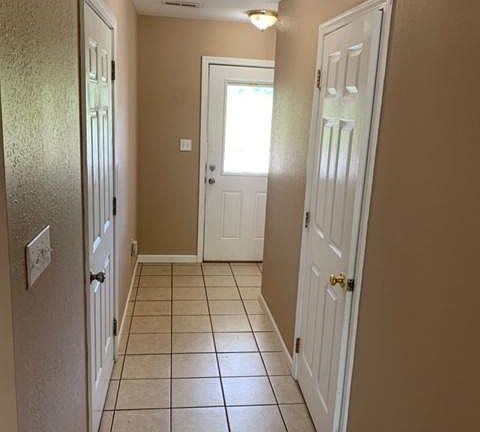 Entryway into townhome with doors to half bath and garage