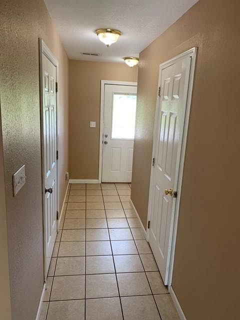 Entryway into townhome with doors to half bath and garage