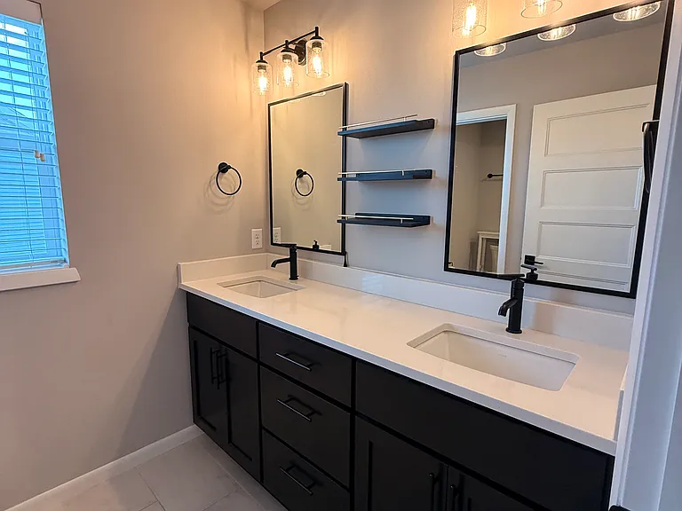 Primary bath has double sinks, separate mirrors, upgraded lighting package and cabinetry.