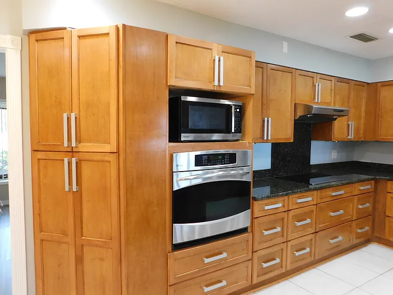 A built-in range sits below the microwave and an electric cooktop is just under the range hood. Look at all the cabinets & drawers!