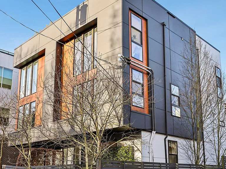 Modern townhome with chef's kitchen, sun-filled spaces, open railings, and hardwood floors.
