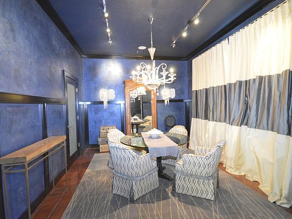 The Formal Dining Room features crown molding, track lighting, a chandelier & wood floors.