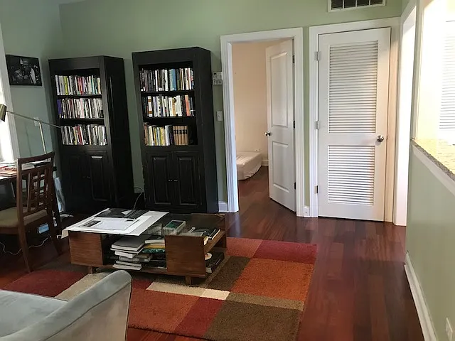 Main room. Note there is an open wall between the kitchen sink which provides space and light from the kitchen in to the living room. Left door opens into the bedroom. The right door is an HVAC closet with additional storage opportunities.