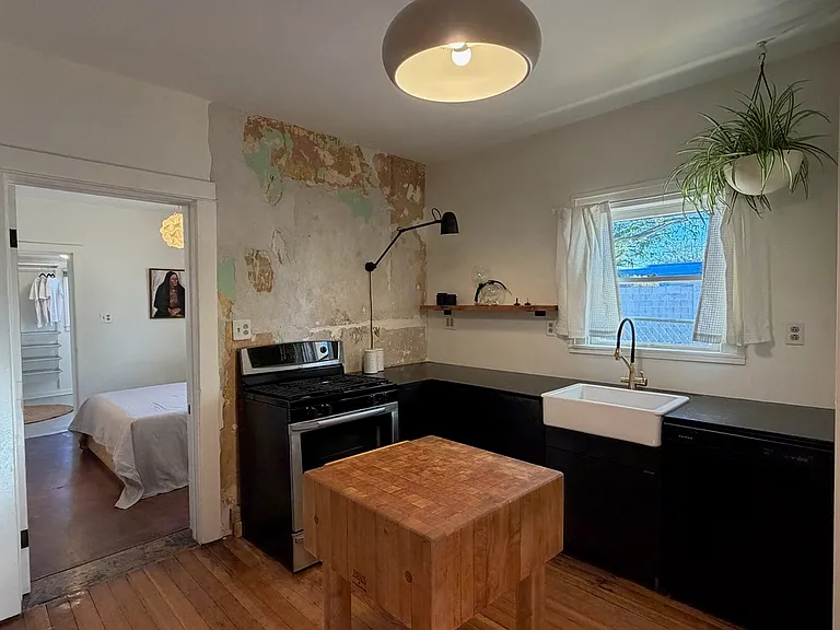 Kitchen with distressed wall - facing sink