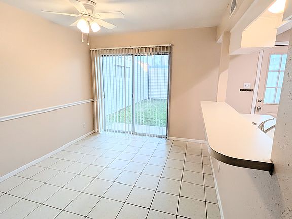 Tiled dining room with sliding door access to the fenced back yard and patio.
