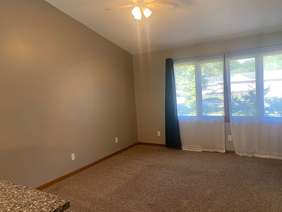 Main floor living room with large windows, ample lighting and vaulted ceilings