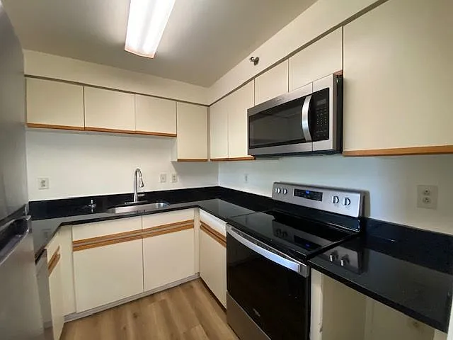 Updated kitchen with vinyl plank flooring, and stainless-steel appliances plus granite.