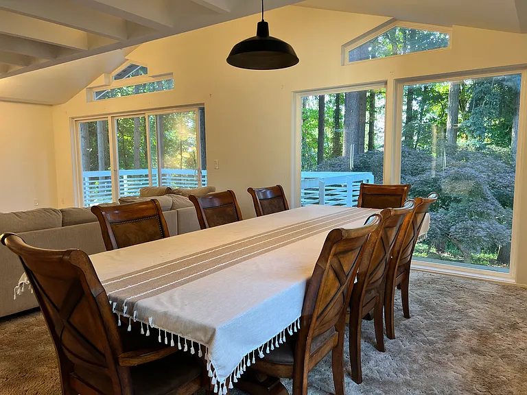 The spacious dining area is surrounded by views of mature trees, creating a cozy and lodge-like atmosphere.