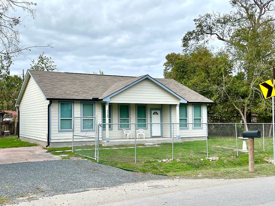 Front of house with new rock drive and pathway, gutters, manual gate