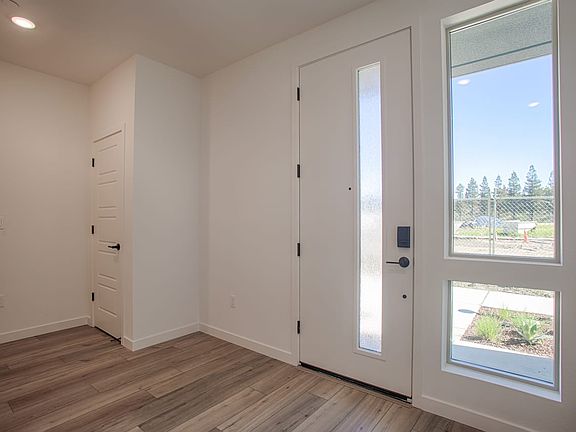 A bright and spacious entryway with a large window overlooking a scenic outdoor landscape, featuring