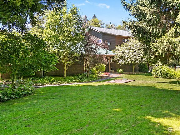 Front yard with garden space and fruit trees.>