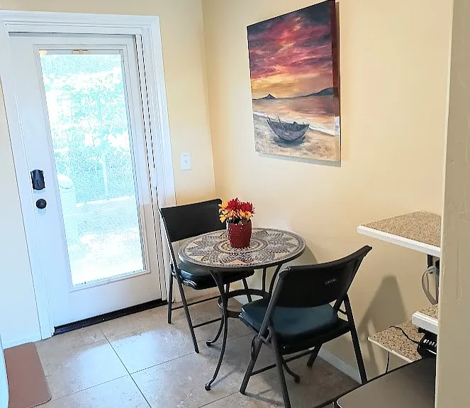 Charming dining area furnished with a beautiful mozaic table and artwork,