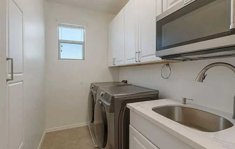 Laundry with Washer Dryer, Microwave, Large sink and storage with built in Iron Board