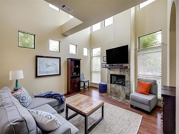 Living area w/ high ceilings and a wall of windows allowing for an abundance of natural light!