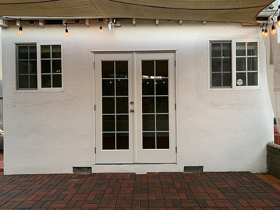 Back doors open up to bistro lit outdoor space ready for hosting and lounging.