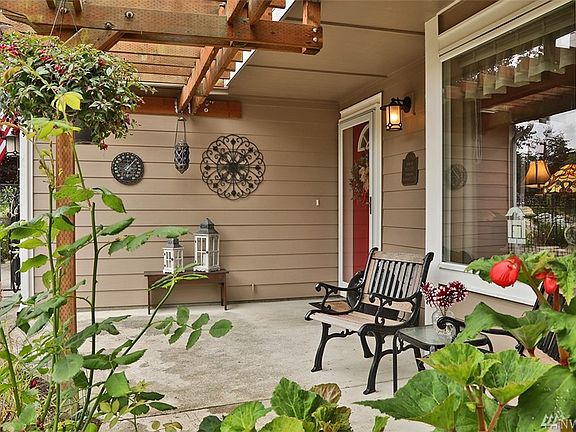The covered front porch with pergola is one of the many outdoor spaces to relax. 