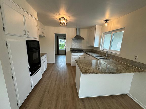 Kitchen with dishwasher, oven and new range and hood, granite counter tops.