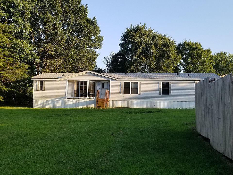 Front yard of home tucked back off main road. Privacy fence is neighbors back yard