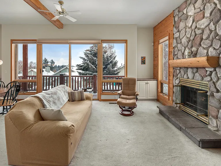 Living room with fireplace and deck with a view of the mountains