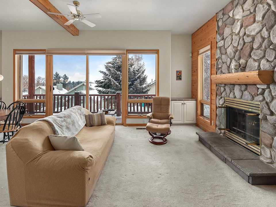 Living room with fireplace and deck with a view of the mountains