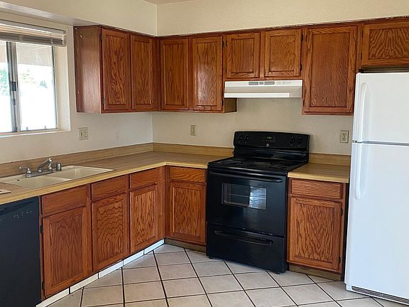 Kitchen includes electric stove, refrigerator and dishwasher.