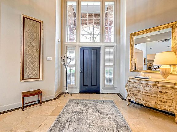 Sophisticated 2 story entry with abundant natural light reflecting the elegance of the travertine tile flooring.