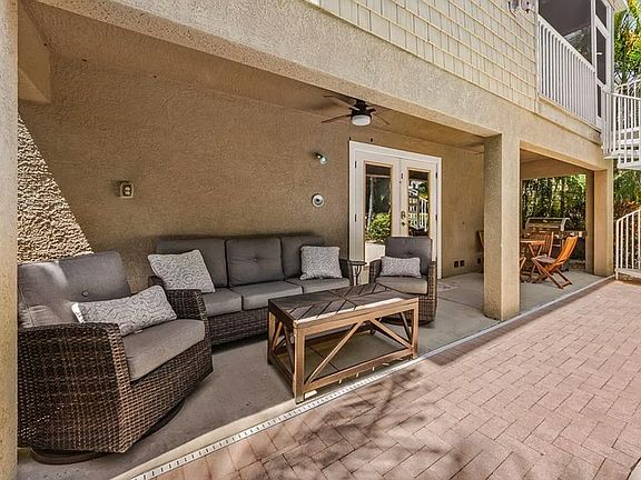 Back of the house by the heated pool, three comfortable lounge areas, and a gourmet grill for outdoor entertaining.