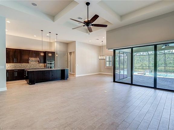 GREAT ROOM WITH PLANK STYLE TILE AND SCULPTURED CEILING DETAIL.