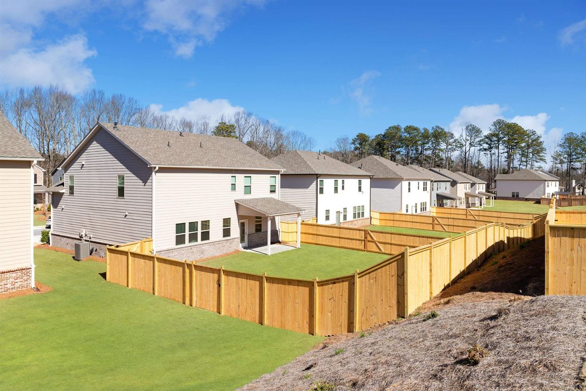 Exterior view showcasing the spacious and beautifully landscaped backyards of Baxter Woods Homes.