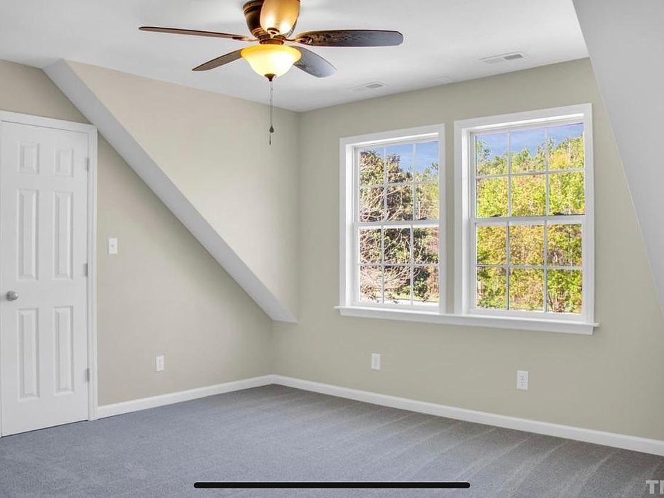 Bright large bedroom with ceiling fan and brand new carpet.