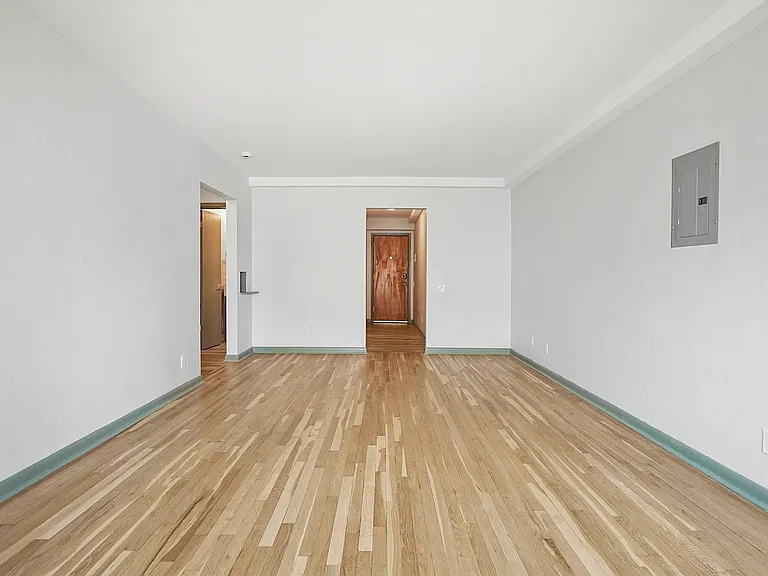 Bright and spacious living room with polished hardwood floors and a minimalist design, perfect for modern living.
