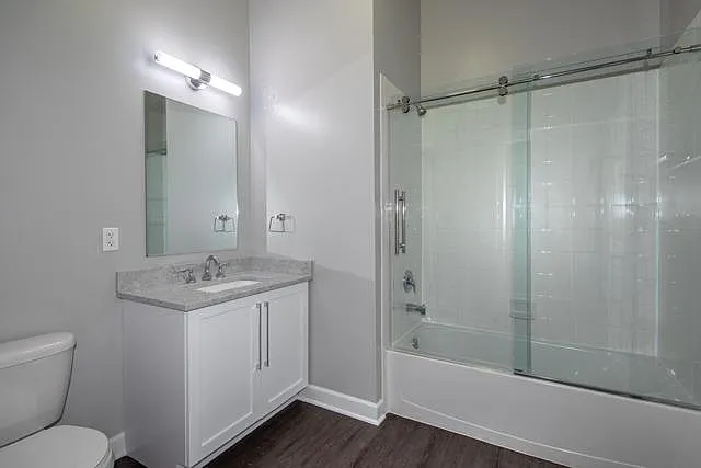 Quartz Vanity, Plank Floor Tile, Barn-Style Frameless Shower Bath