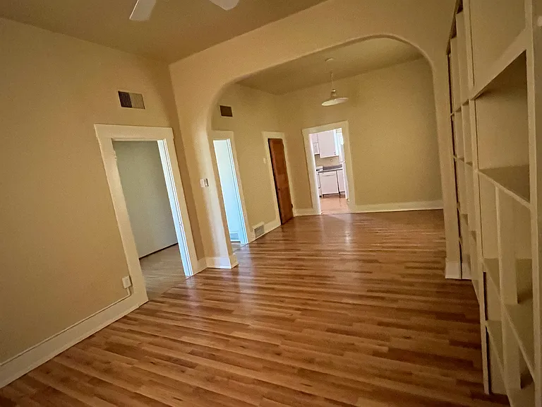 Living room with fan and dining room with extra closet, looking into kitchen.