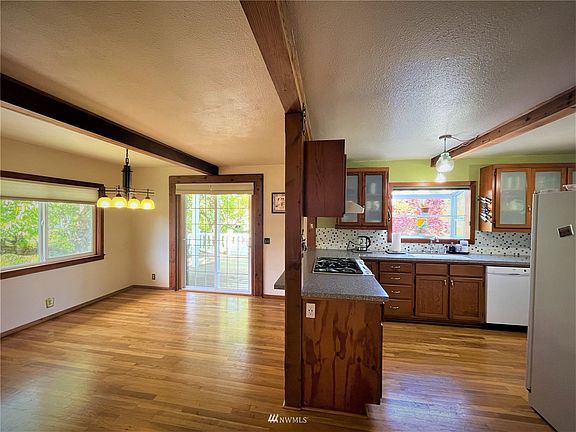 Stepping in towards your dining room open pass-through counter to kitchen with beautiful beams. French doors lead to the huge 2nd deck for more space to host guest on the warm days and evenings