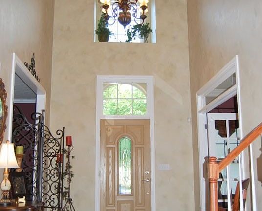 Two-story foyer with hardwood floors and chandelier
