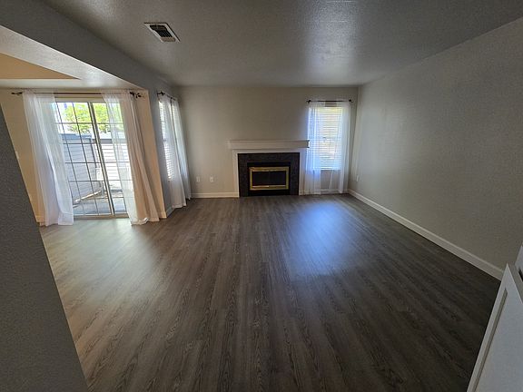 Spacious living room with cozy fireplace, luxury plank flooring, and sliding glass doors leading to your second private outdoor deck.