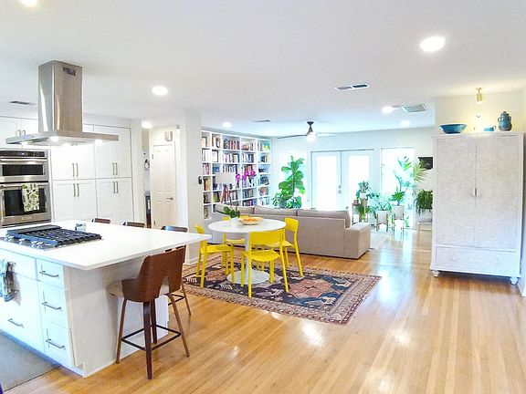 View from front door entrance- bright, naturally lit, shining modern home with views to the south-facing wall of windows. Open concept floor plan. Gleaming hardwood floors, high-end kitchen.