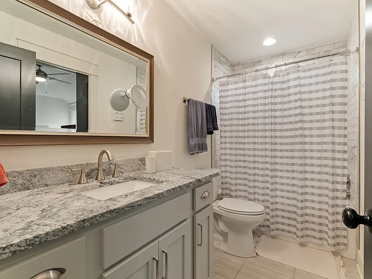 The Jack and Jill bathroom has modern tile and a large vanity with plenty of counter space and storage.