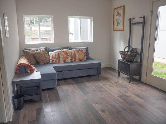 Brightly lit living room with skylit and pullout couch that sleeps two.