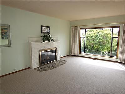 Living room with woodburning fireplace and south-facing front window.