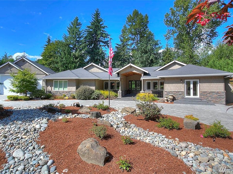 Welcome home to The Grove. Luxury and style embody this exquisite custom 4 bedroom, 3 ½ bath rambler.  Stunning design features, expansive living spaces, high ceilings and light-filled rooms have been masterfully designed to highlight the beautiful Northwest setting of this home. The sweeping double door entry and tiled foyer, Chef's dream kitchen, master suite with fireplace, ensuite bathrooms for each guestroom, indoor swim spa and temperature controlled wine cellar are just a sample of the luxury features of this home. All spaces in this home flow beautifully for easy entertaining, both indoor and out. A four-panel French door opens from the family room to the deep covered wrap-around deck and takes full advantage of the gorgeous back yard and grounds. A secure gated entry, and stone paver circular drive provide a lovely approach. An enormous detached garage features large bay doors for indoor RV parking, 240 amp power, and a 3/4 bath. 