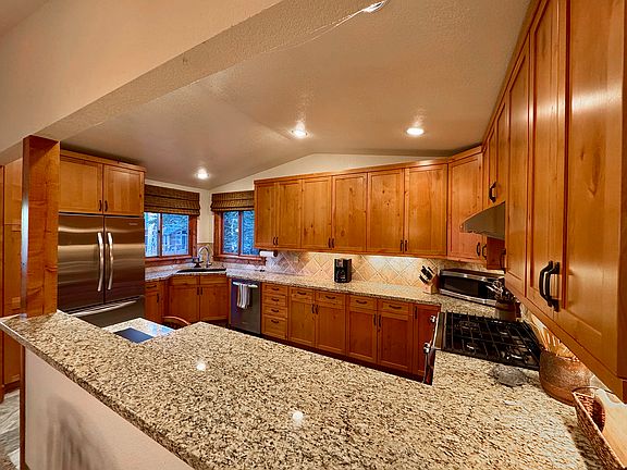 Large kitchen with new stainless steel appliances and granite counters. Plenty of cupboards filled with dishes, pots, pans, everything you need.