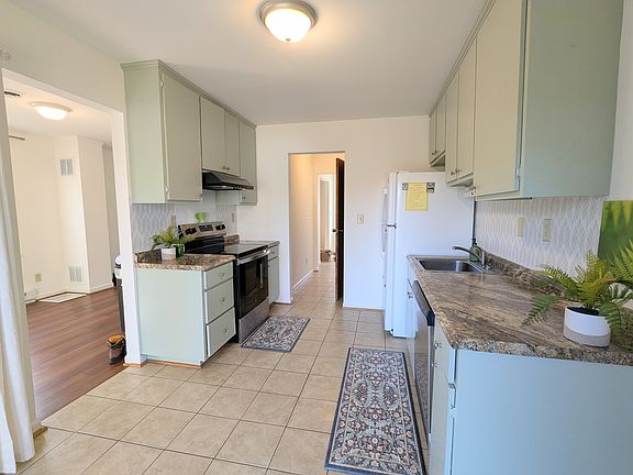 Kitchen with tile floor, hallway includes a half bath.