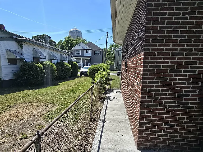 Continuous concrete walkway extending from the front of the home to the back.