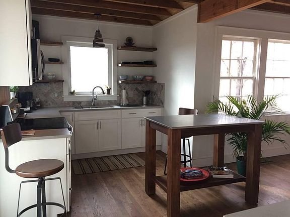 Open kitchen is fully equipped for cooking.