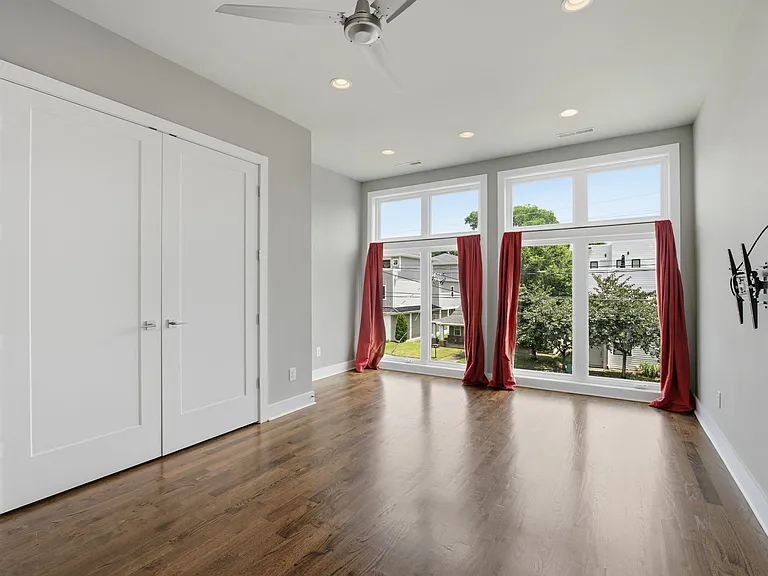 First guest bedroom on the second floor with lots of light, large windows over looking 2nd Ave S and a closet with double doors (drapes will be removed)